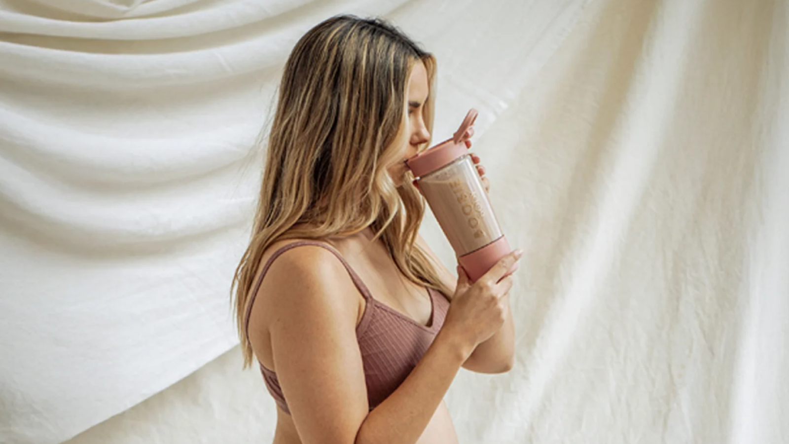 Breastfeeding mom drinking lactation supplement.