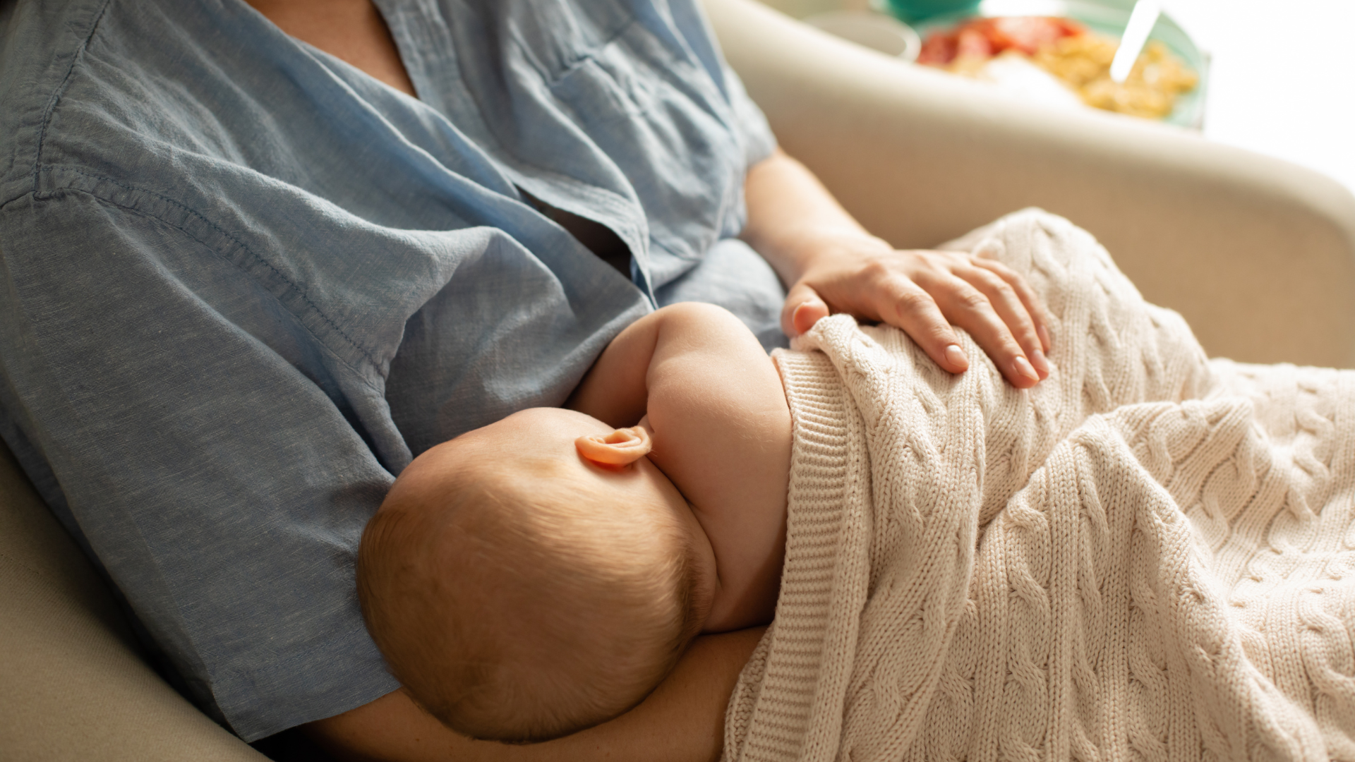 Close-up of mom nursing baby in cradle breastfeeding position