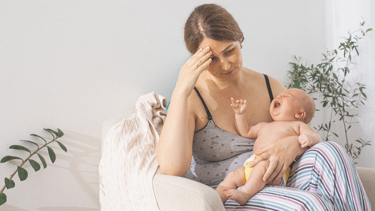 Weary nursing mom weighs safety concerns while soothing her upset newborn