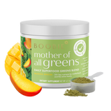 Boobie Mother of All Greens dietary supplement jar with mango slices and scoop on a white background