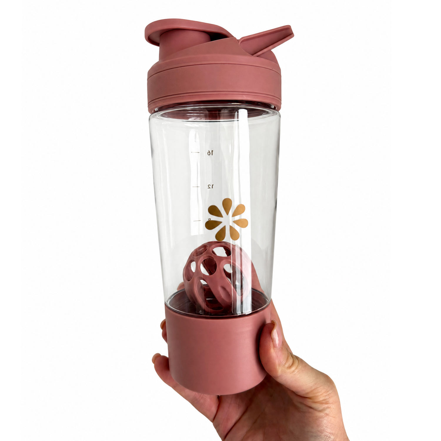Pink blender bottle with a clear middle section and a hand holding it on a white background