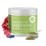 A container of 'Mother of All Greens' dietary supplement with a scoop of the powder and pieces of berry, pomegranate and blueberries displayed in the foreground.